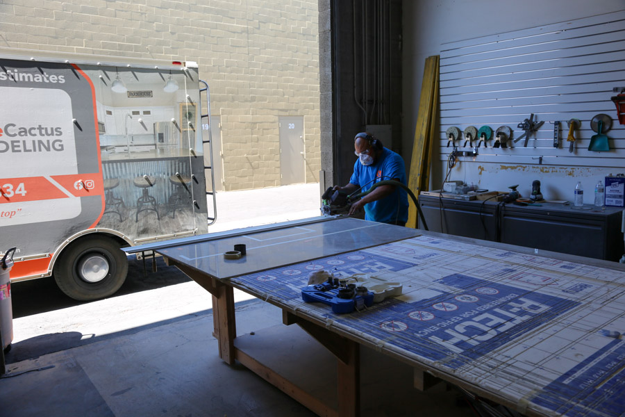 An Orange Cactus Remodeling crew member working at the shop beside the company van